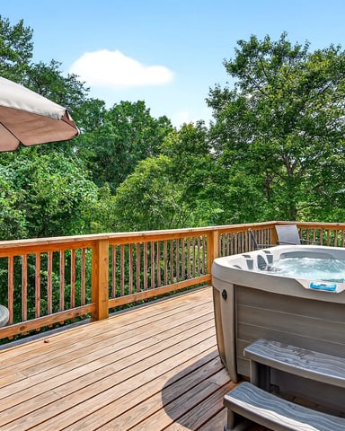 Stone firepit with Adirondack chairs set in a wooded backyard